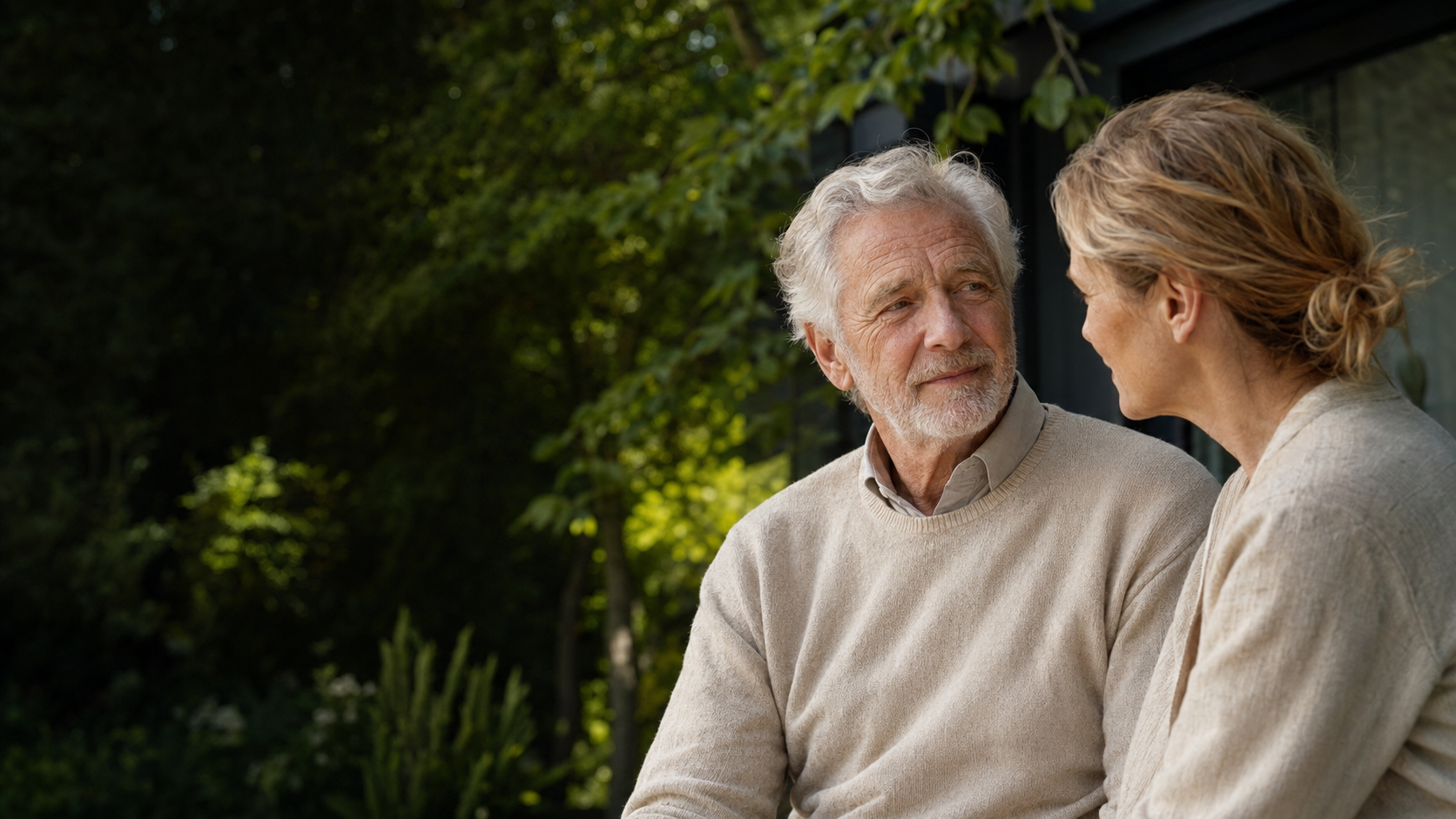 An older father and adult daughter sharing a relaxed moment outdoors